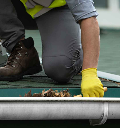 Man on the roof cleaning gutters